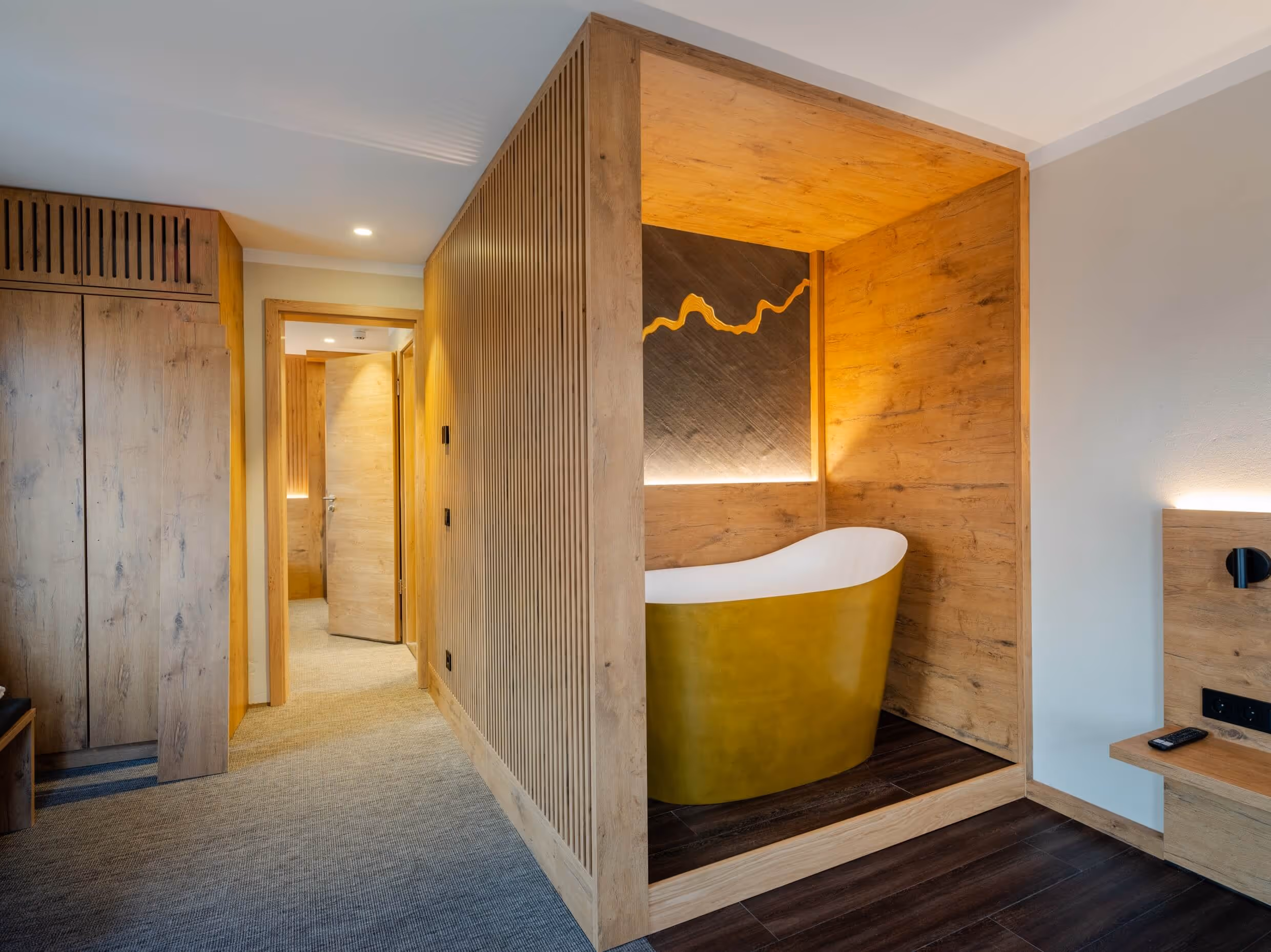 Modern Japanese-style suite, at the Nashi Rooms Hotel in central Erfurt, with a free-standing golden bathtub in a wooden alcove.