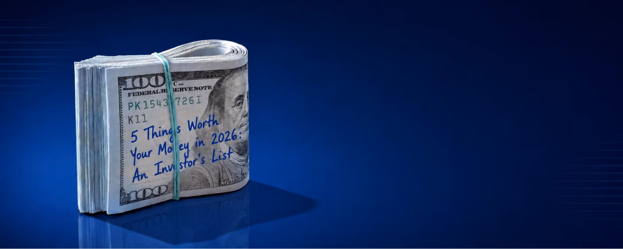 Bundle of U.S. $100 bills wrapped with a rubber band on a glossy blue surface, with the handwritten title “5 Things Worth Your Money in 2026: An Investor’s List” on the front note against a dark blue background.