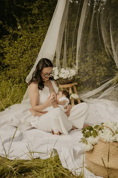 Photographe maternité Loire-Atlantique — maman allaitant son bébé dans un cadre bohème à l'extérieur