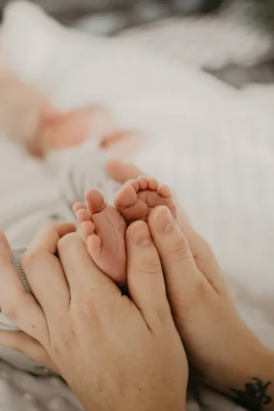 Photographe maternité Loire-Atlantique — détails pieds de bébé dans les mains de papa