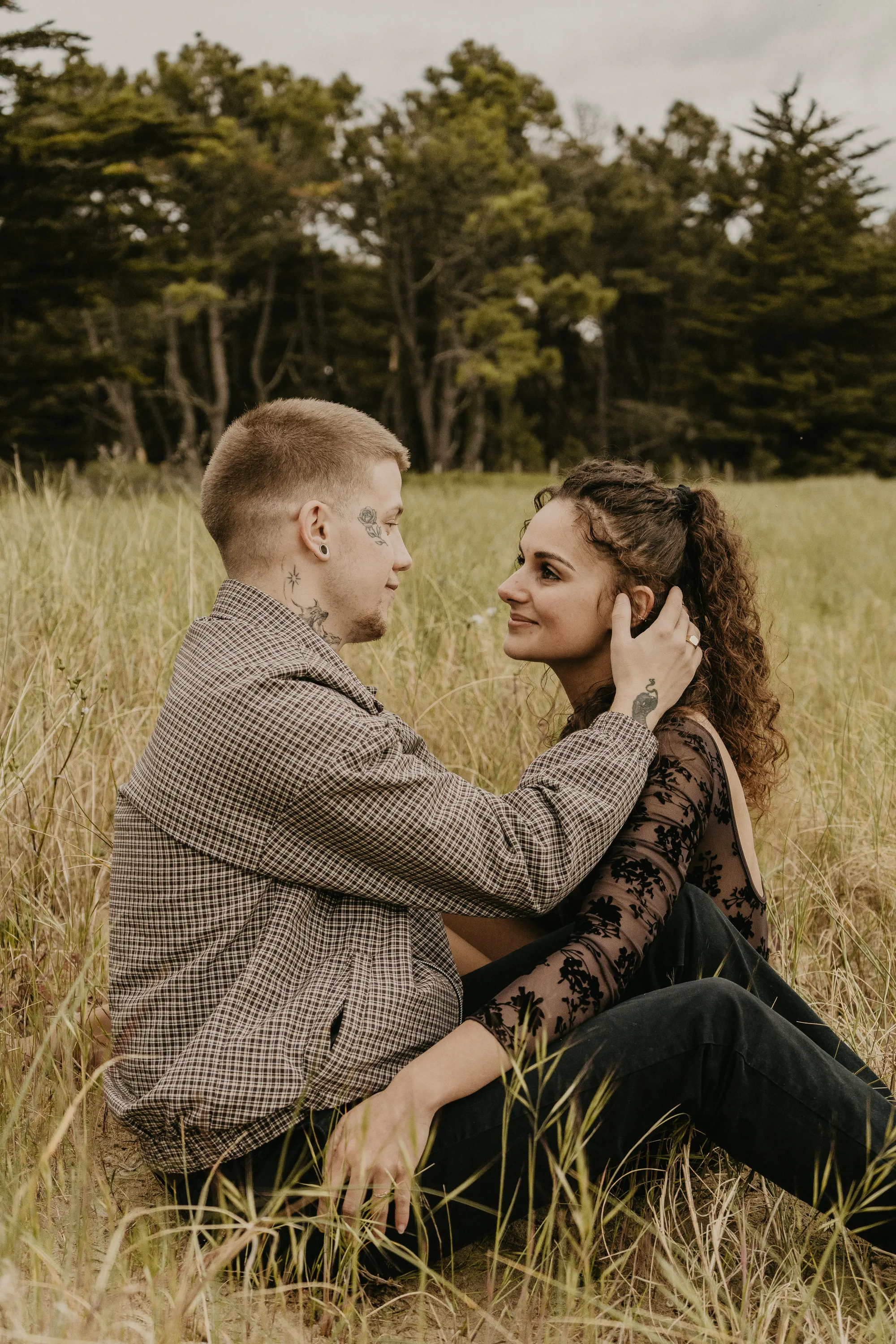 Photographe famille Loire-Atlantique — couple assis dans un champ et se regardant dans les yeux