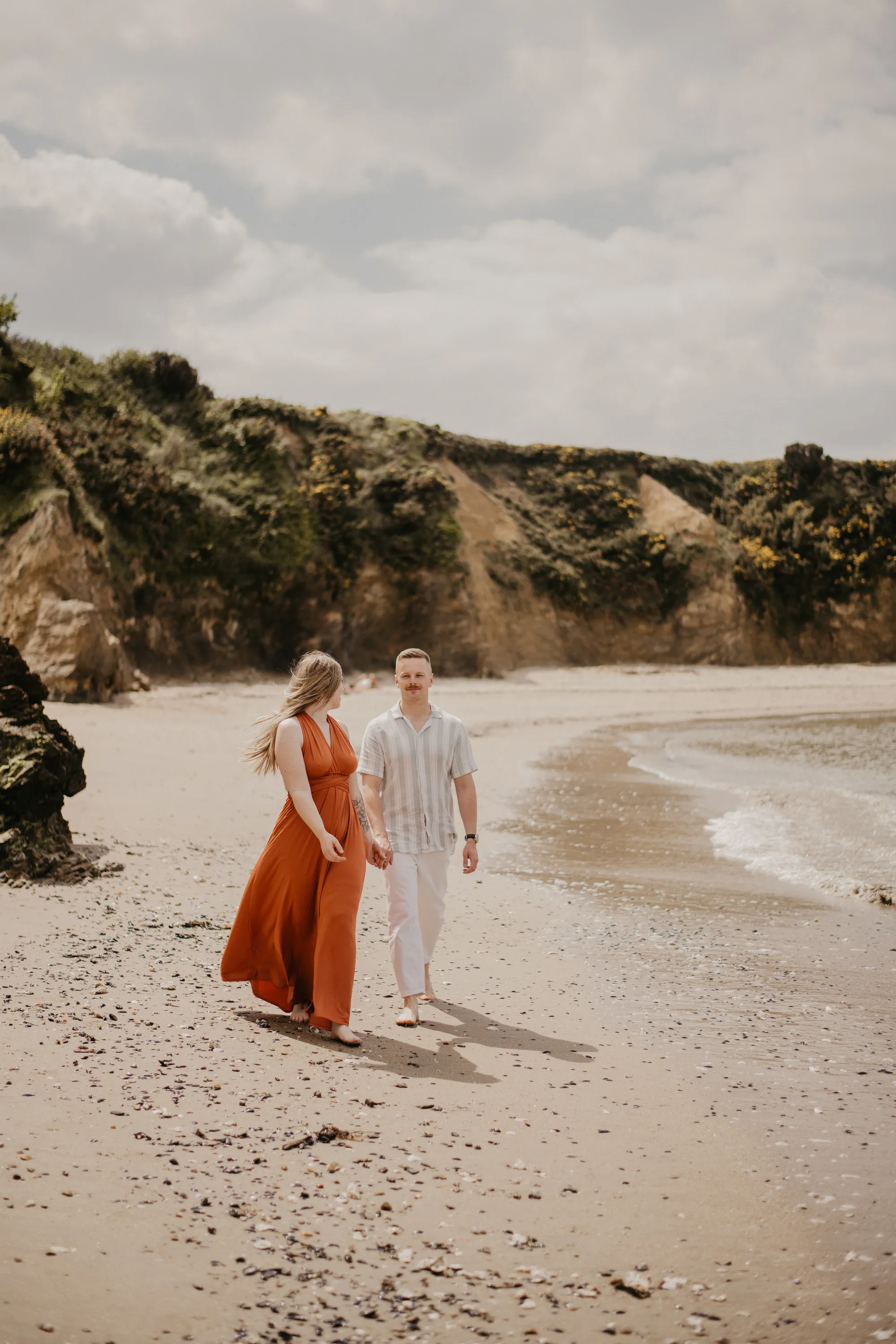 Photographe couple Loire-Atlantique  - couple marchant en bord de plage se regardant dans les yeux