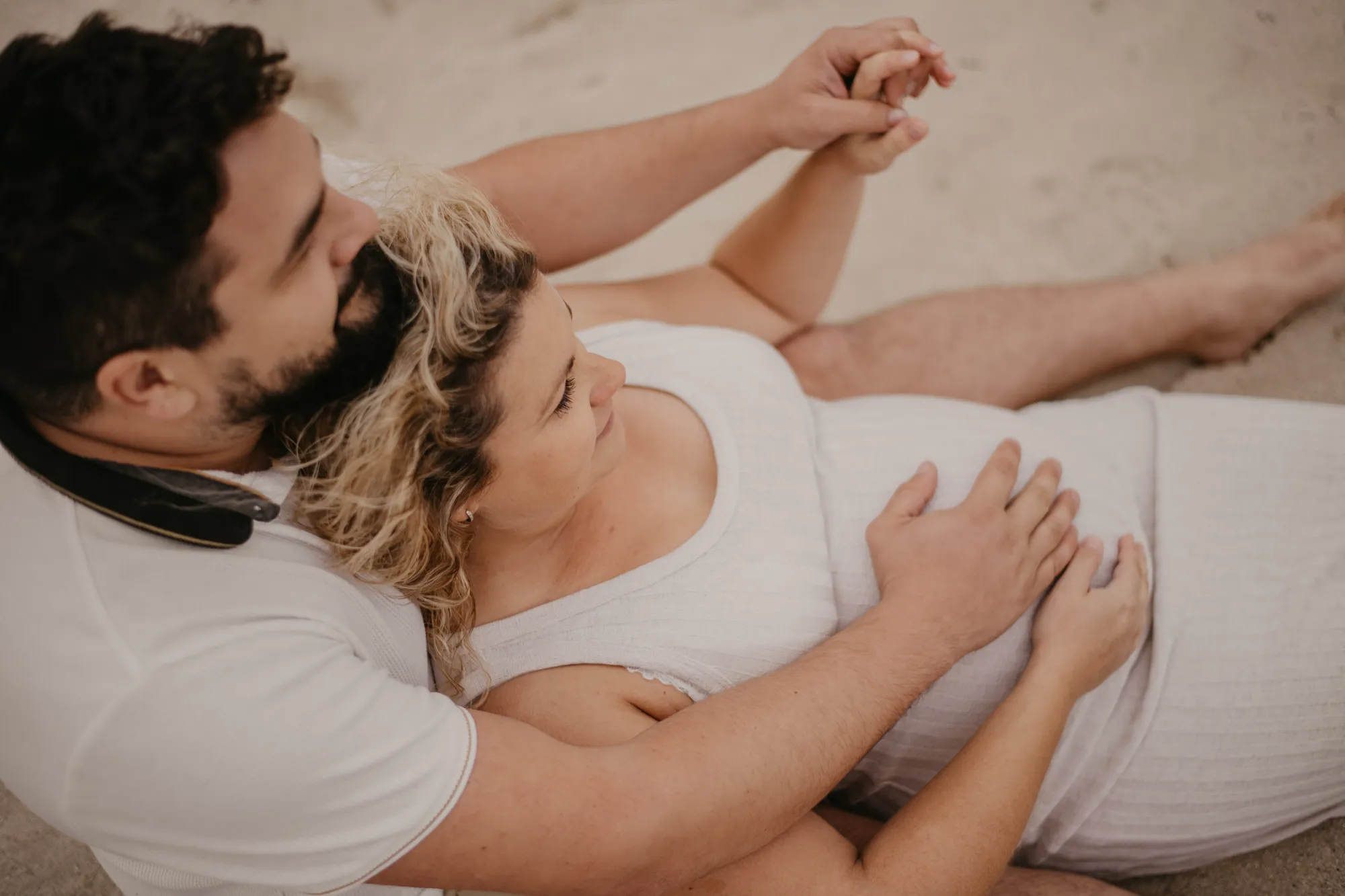 Photographe maternité Loire-Atlantique — femme enceinte  et son conjoint touchant son ventre
