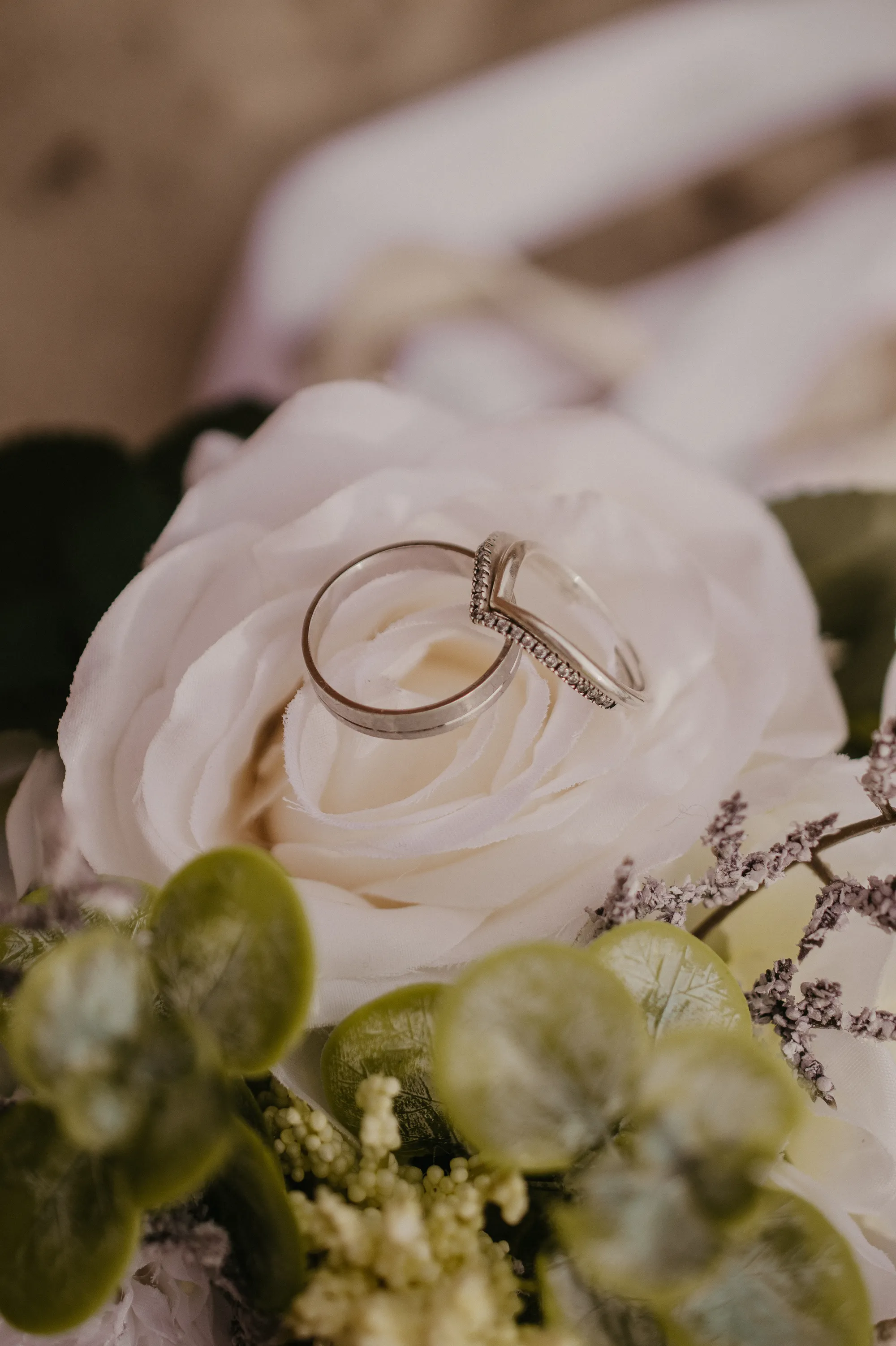 Photographe mariage Loire-Atlantique — détails bagues des mariés sur rose blanche