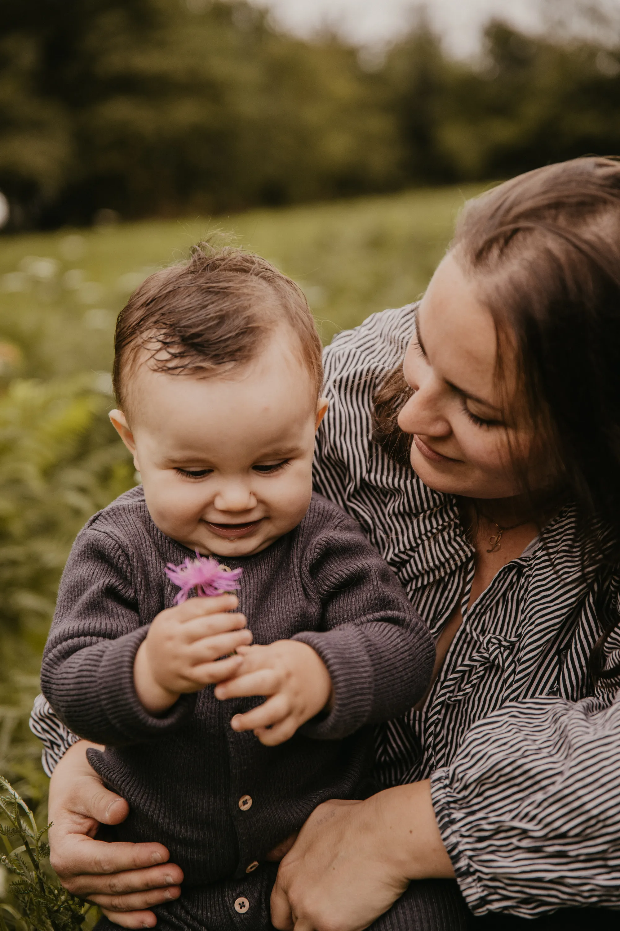 Photographe maternité Loire-Atlantique — maman et son bébé qui tient une fleur violette dans ses mains