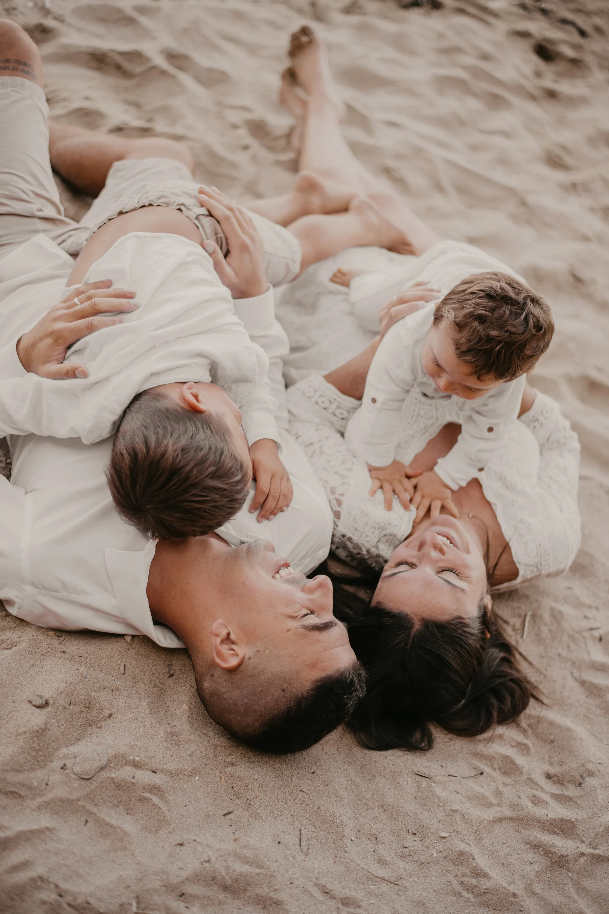 Photographe famille Loire-Atlantique — famille allongée sur le sable 