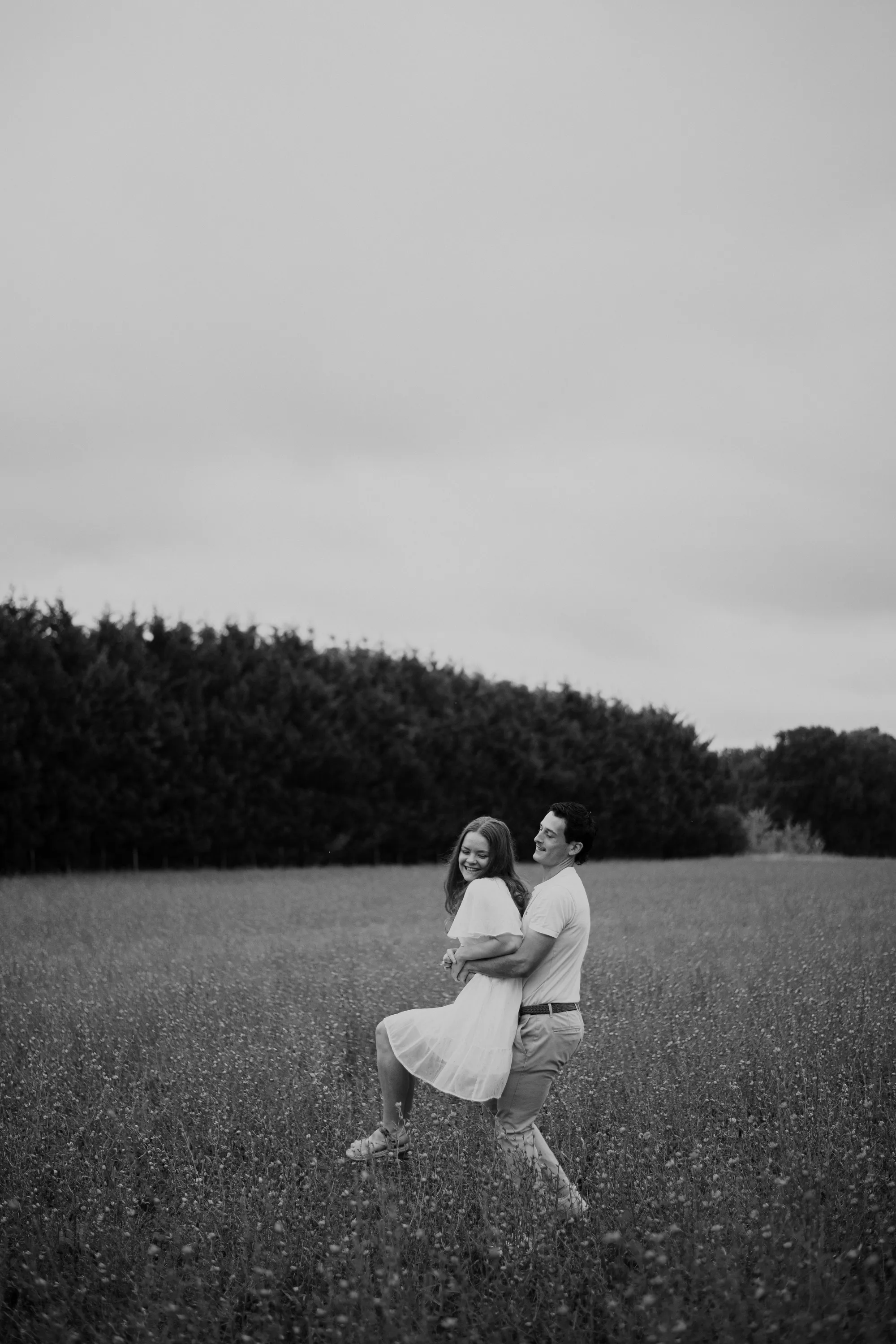 Photographe famille Loire-Atlantique — couple s'amusant dans un champs, photo en noir et blanc
