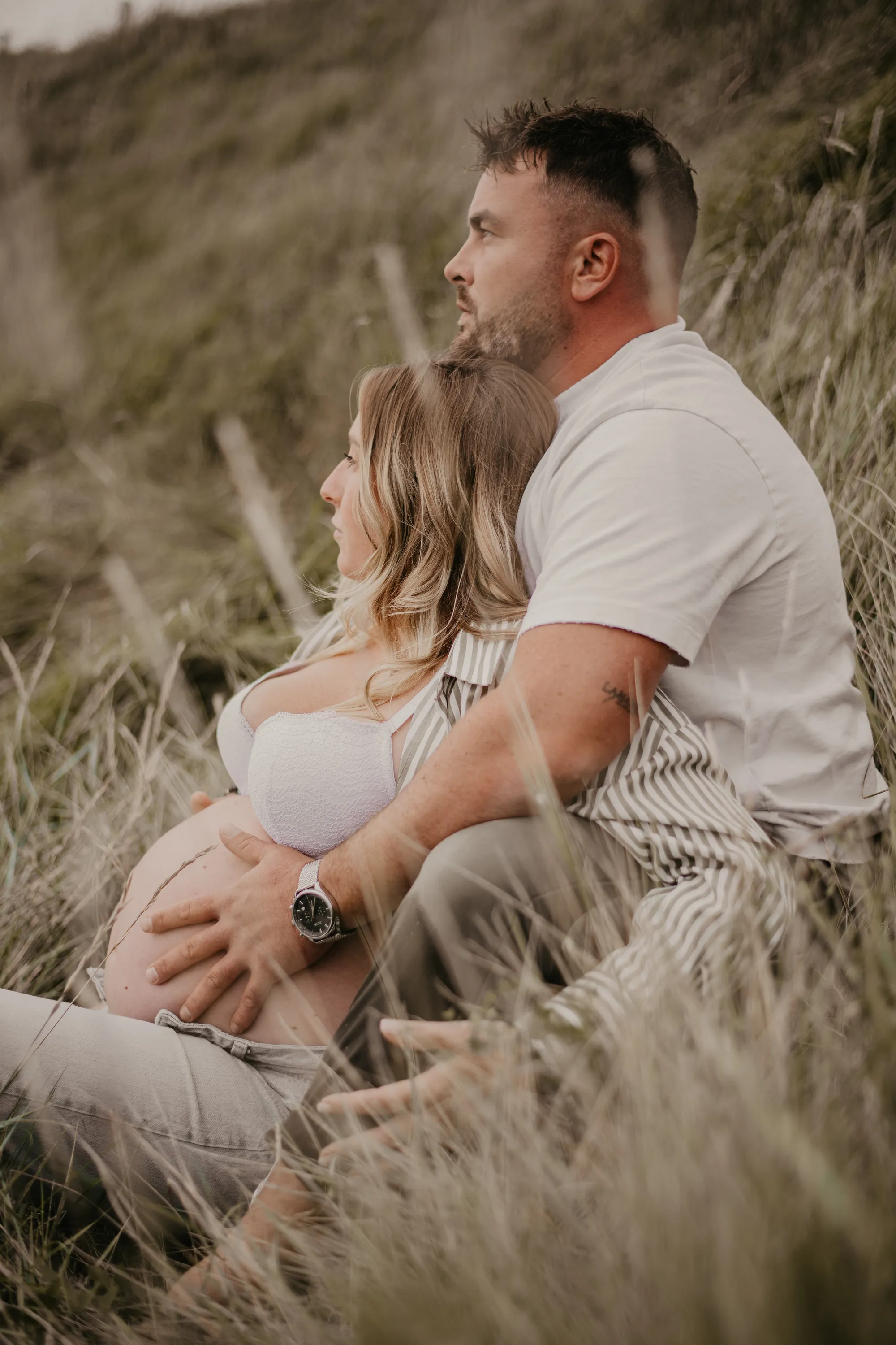 Photographe maternité Loire-Atlantique — femme enceinte avec son conjoint dans un champs