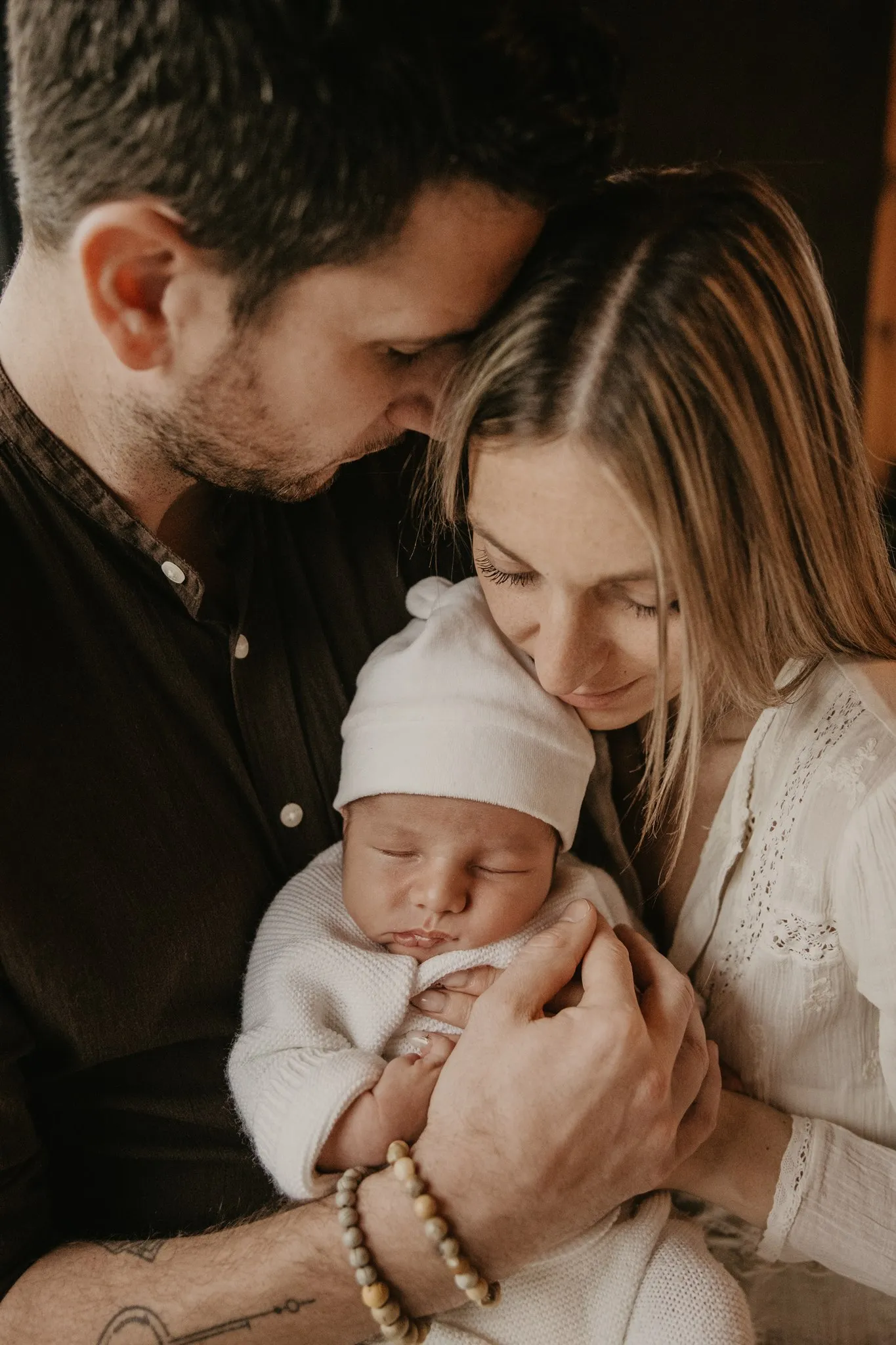 Photographe maternité Loire-Atlantique — parents tenant leur nouveau né dans les bras