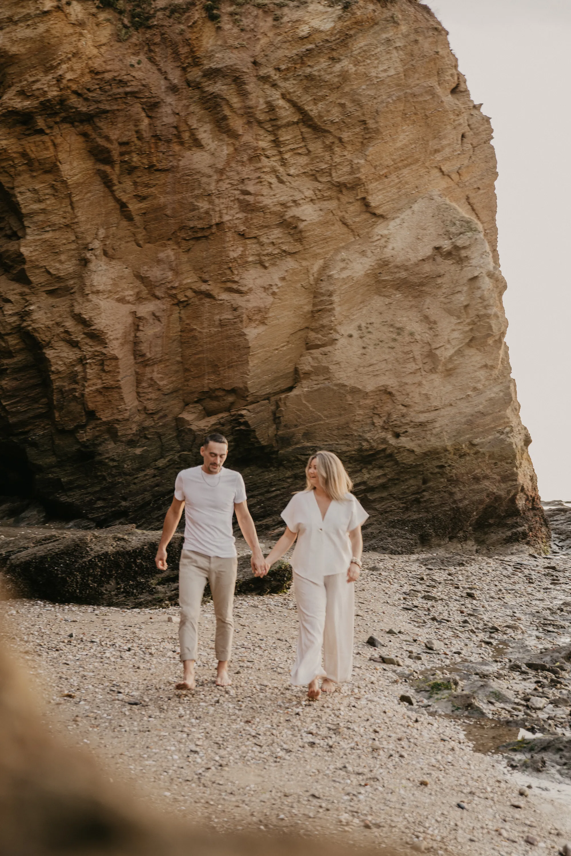 Photographe famille Loire-Atlantique — mère et fils se tenant la main en marchant sur le sable