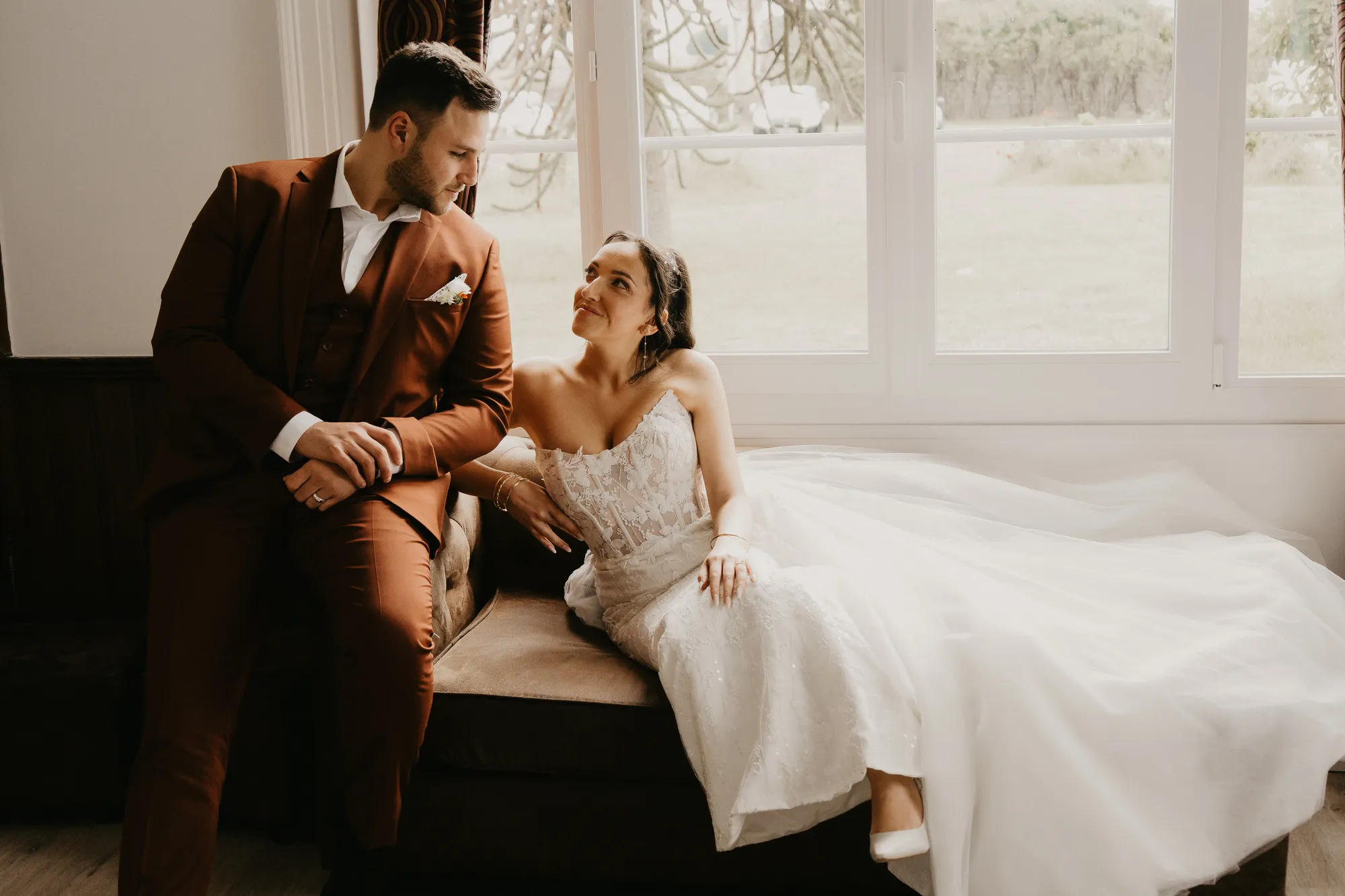 Photographe mariage Loire-Atlantique — mariée assise sur un fauteuil et marié assis au bord se regardant
