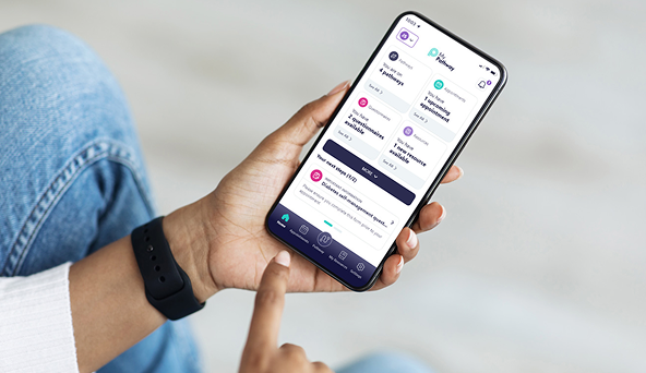 Person holding smartphone displaying a financial app dashboard with balance, expenses, and menu icons.