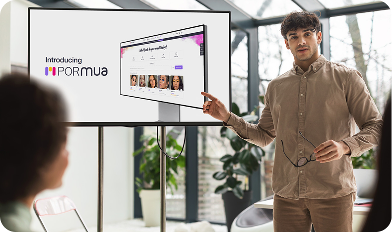 Man presenting a screen showing a website called POR MUA with photos of women's faces.