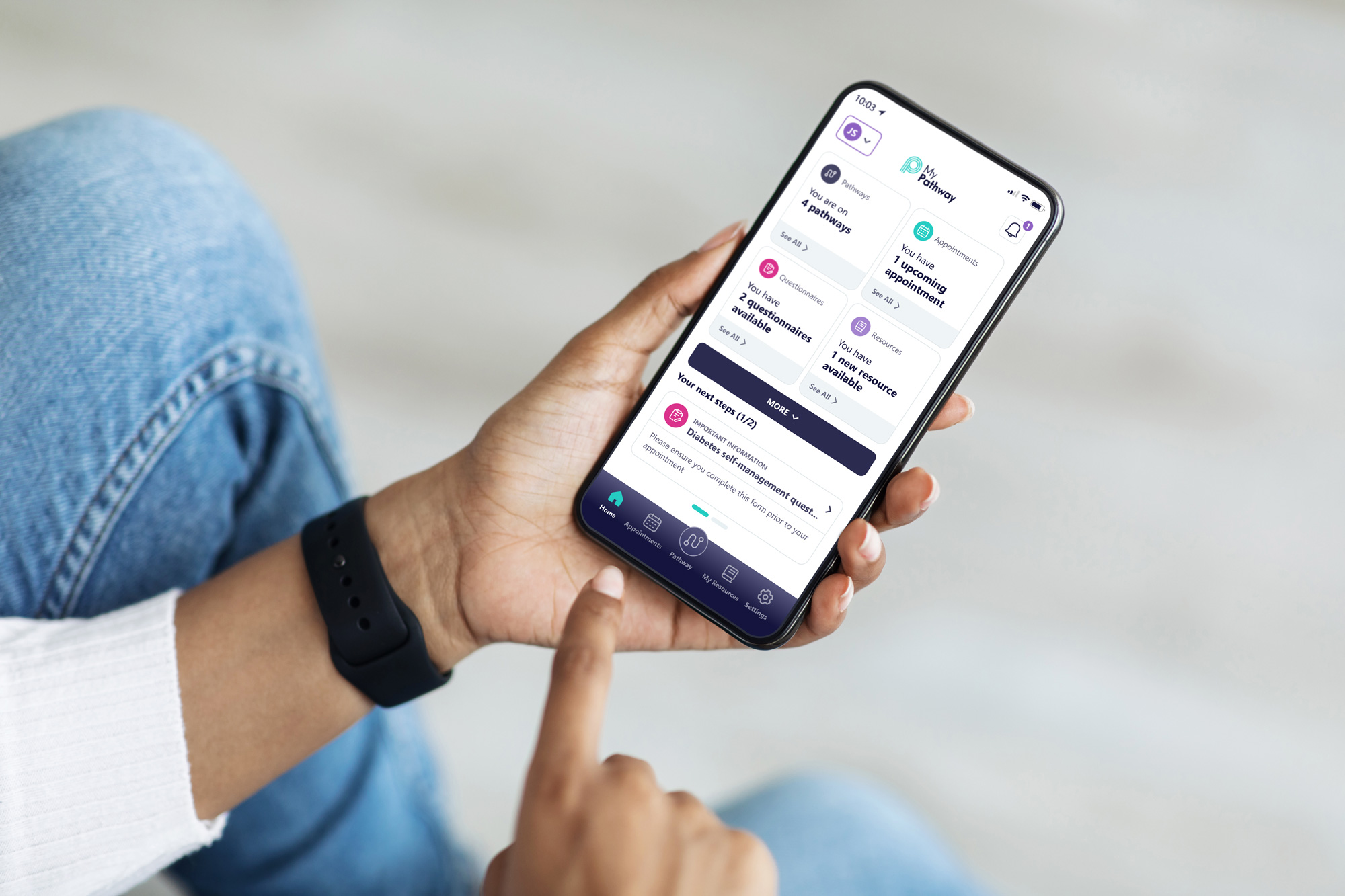 Person holding smartphone displaying health app with pathways, appointments, questionnaires, and resources.