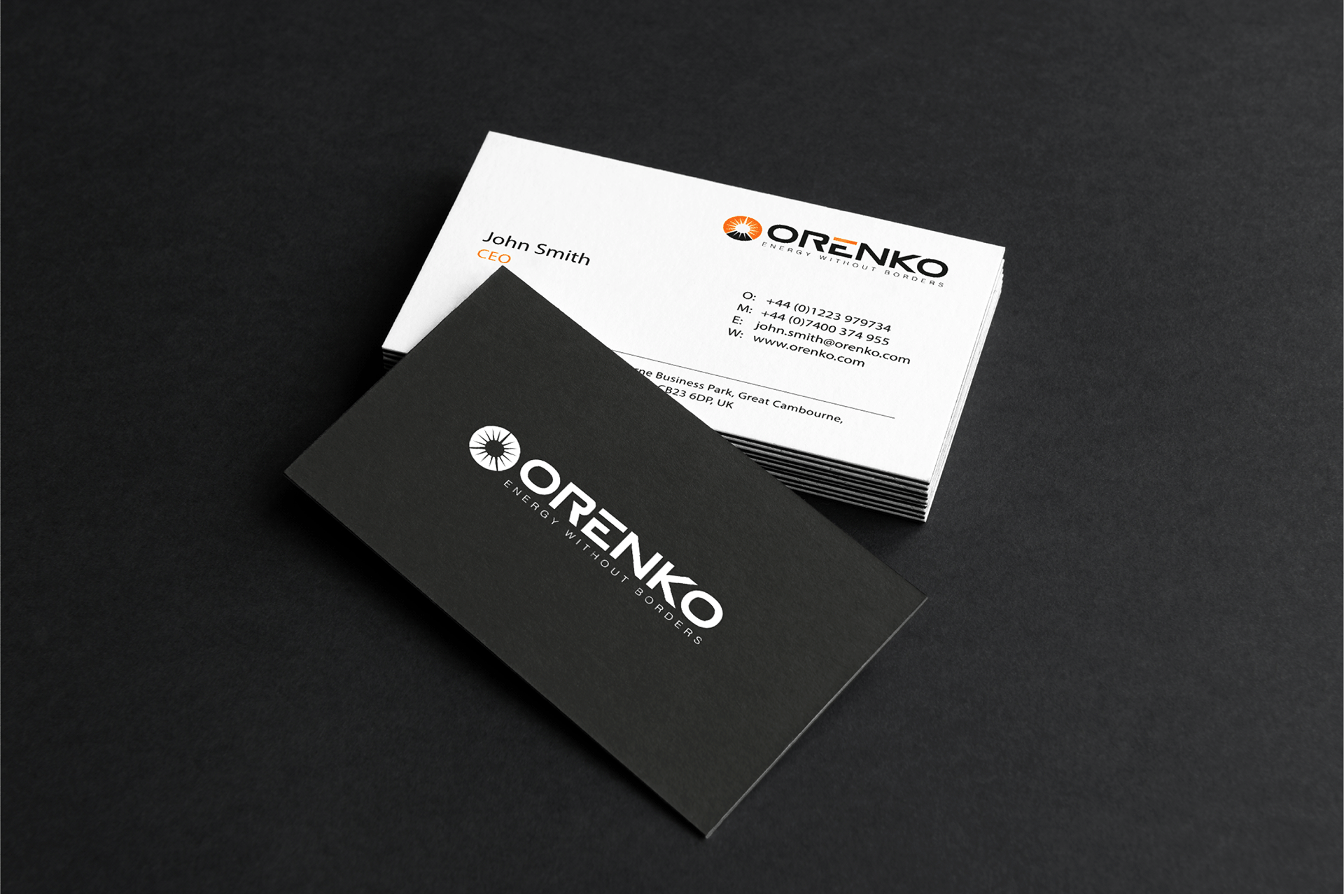 Stack of ORENKO business cards with black card front showing logo and white card with CEO contact details.