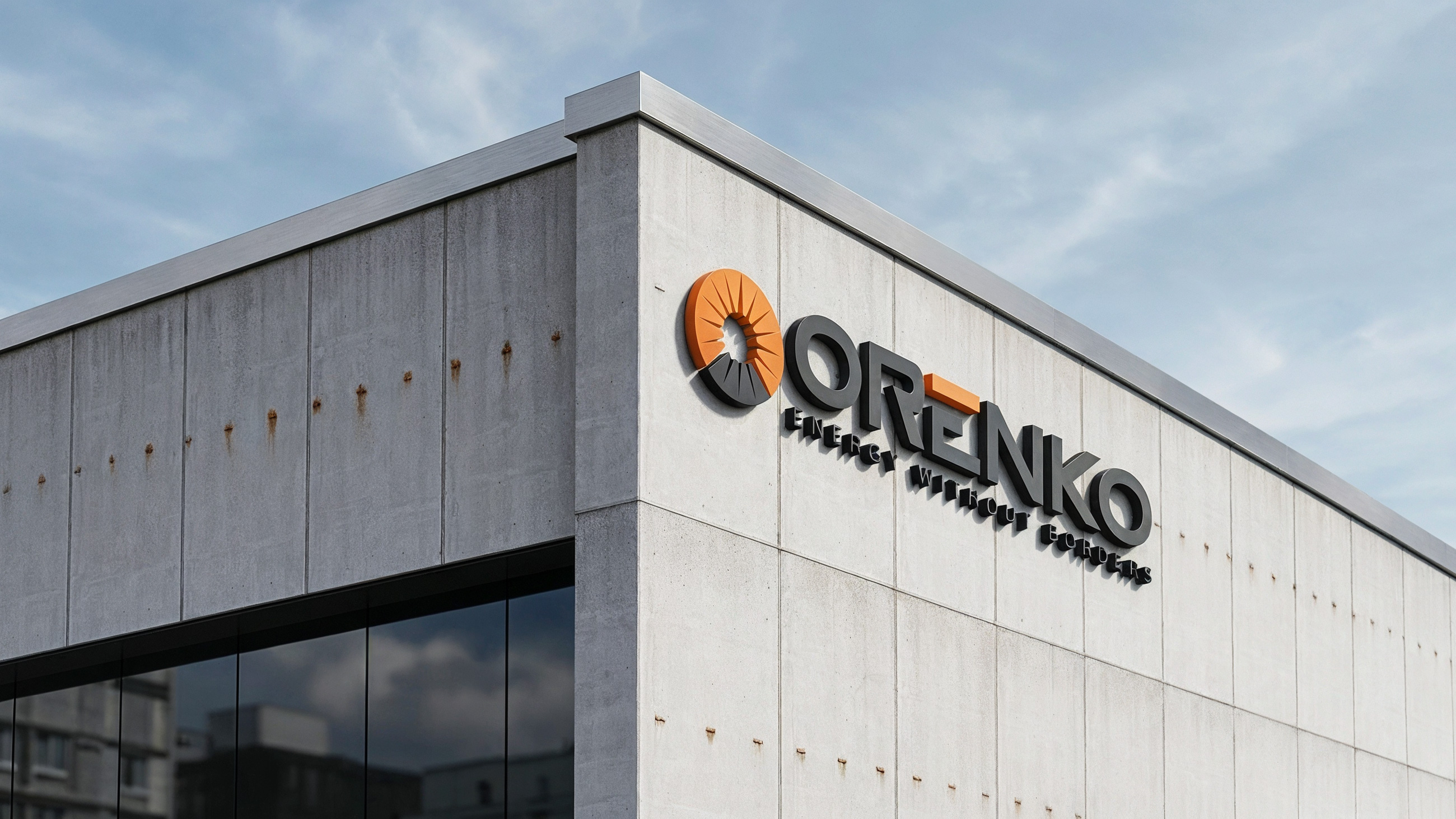 Modern concrete building corner with ORENKO logo and slogan 'Energy Without Borders' on wall.