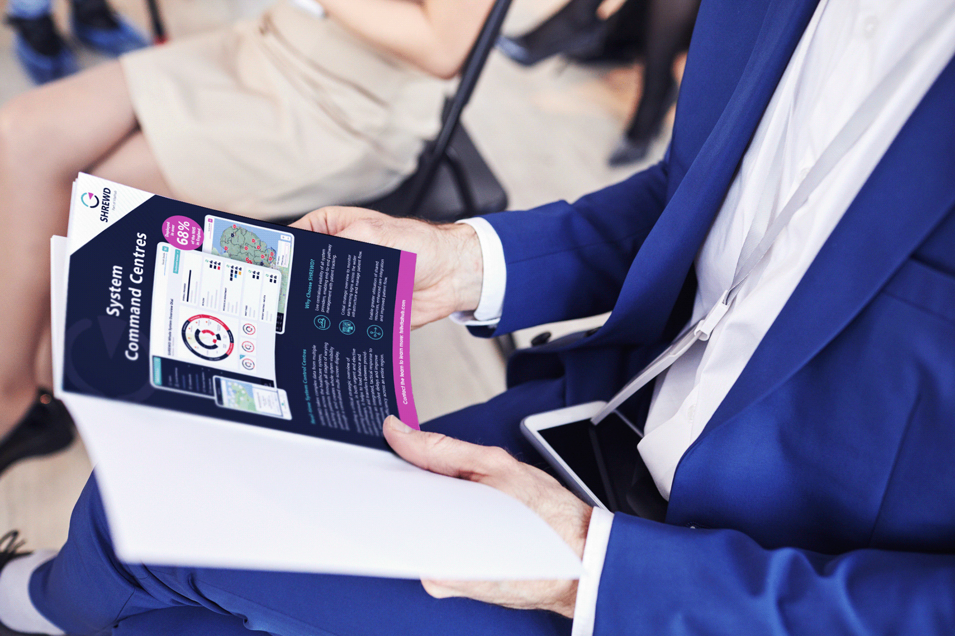 Person in blue suit holding a brochure titled 'System Command Centres' with charts and maps.