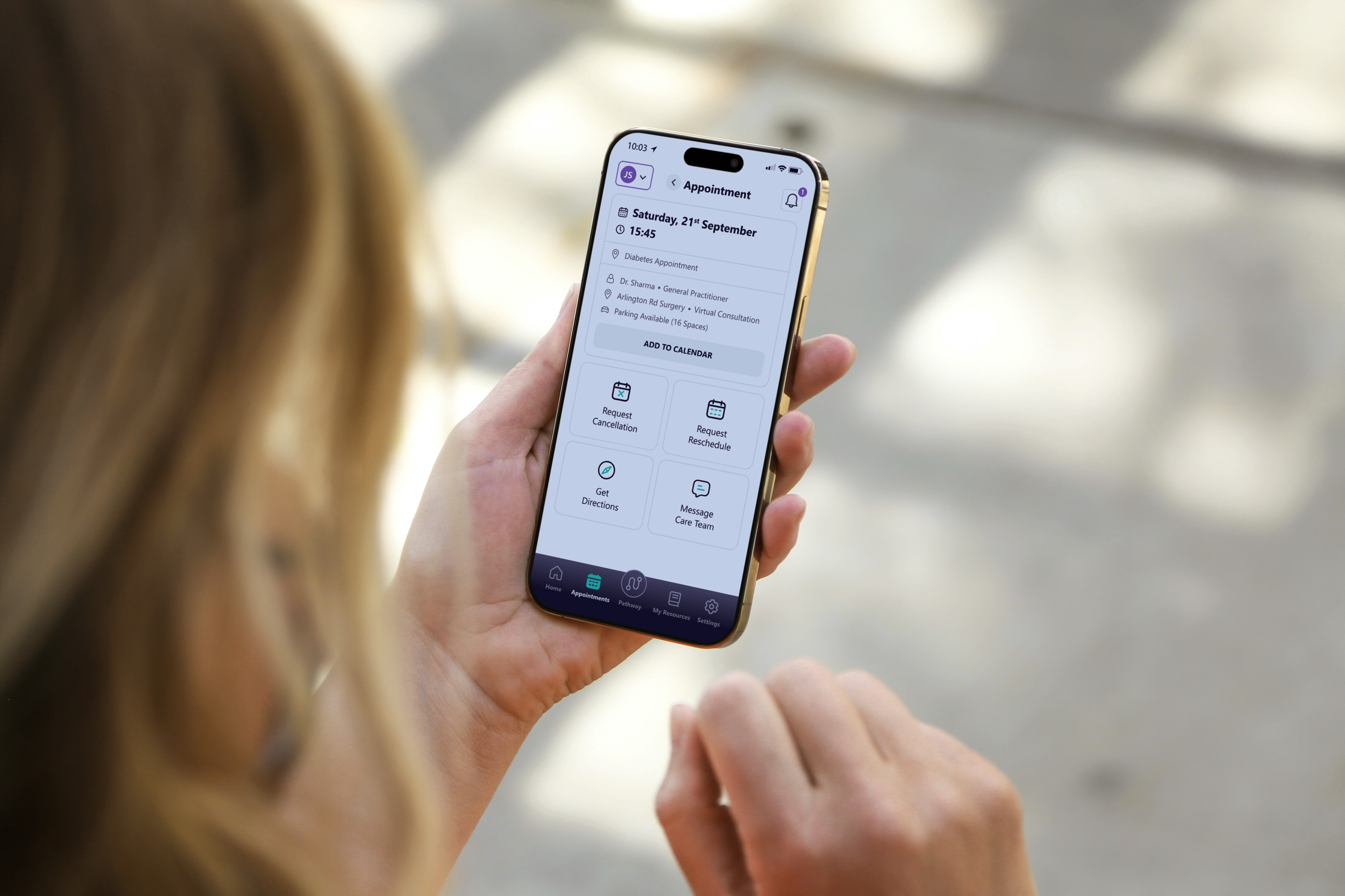 Person holding smartphone displaying appointment details for diabetes with options to reschedule or cancel.