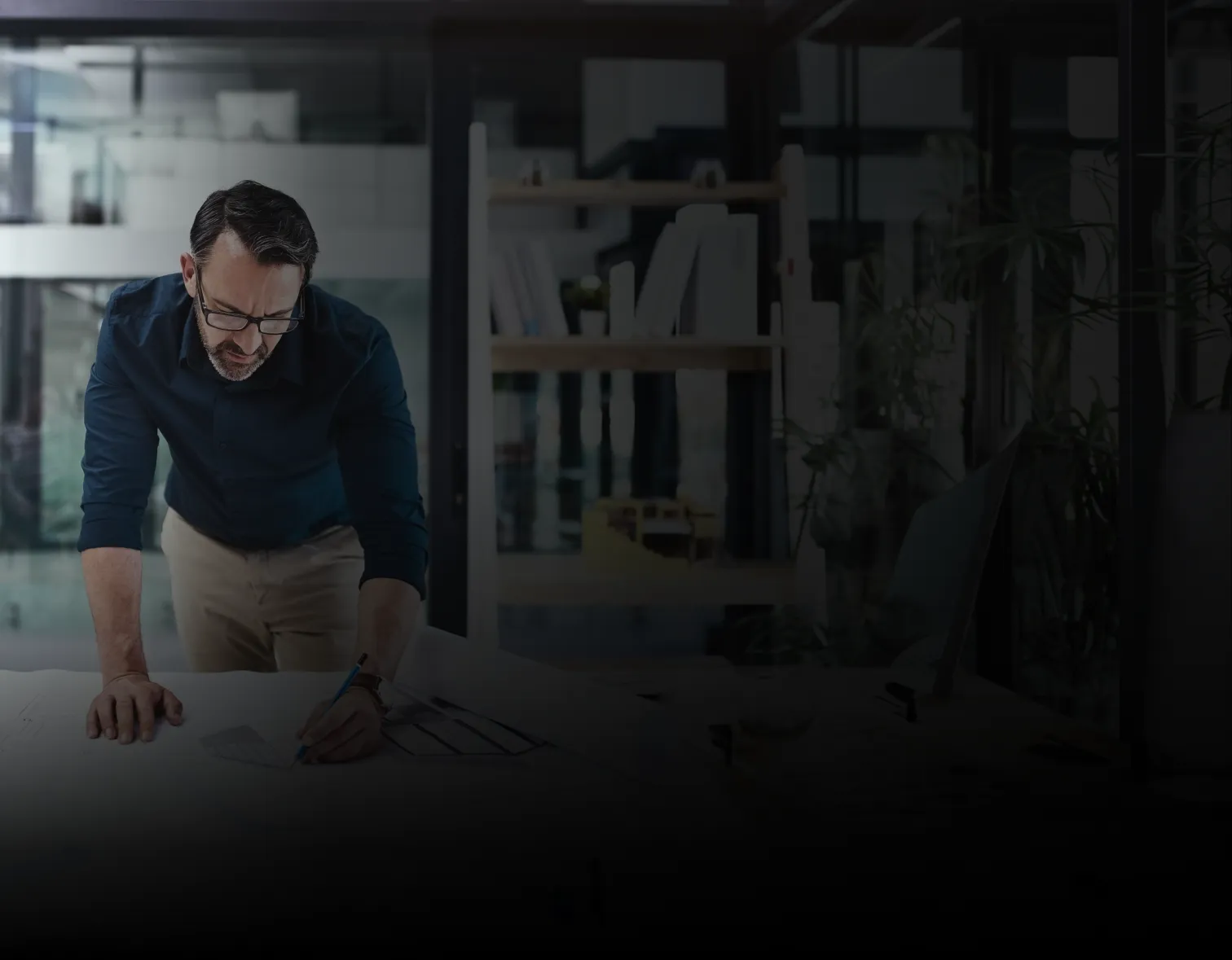Interior designer reviewing architectural plans and design documents at a studio workspace