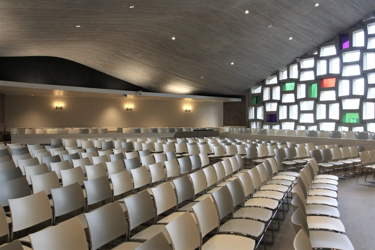 Kerkzaal van Open Hof met lichte kleuren, achterwand en glaswand, ontwerp Agnes Compagne