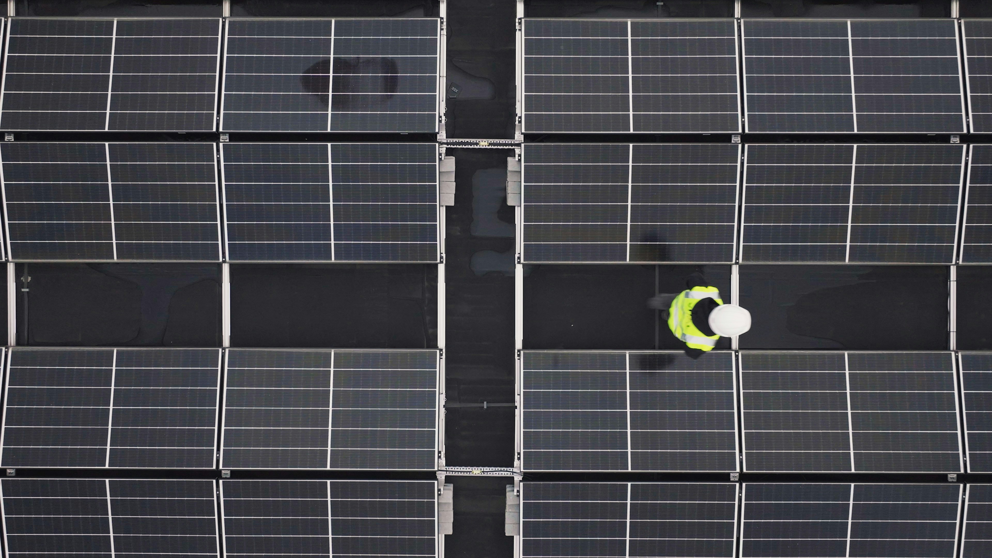 Vue aérienne d'un technicien DRS Energie en inspection sur une grande installation de panneaux photovoltaïques à Mauguio