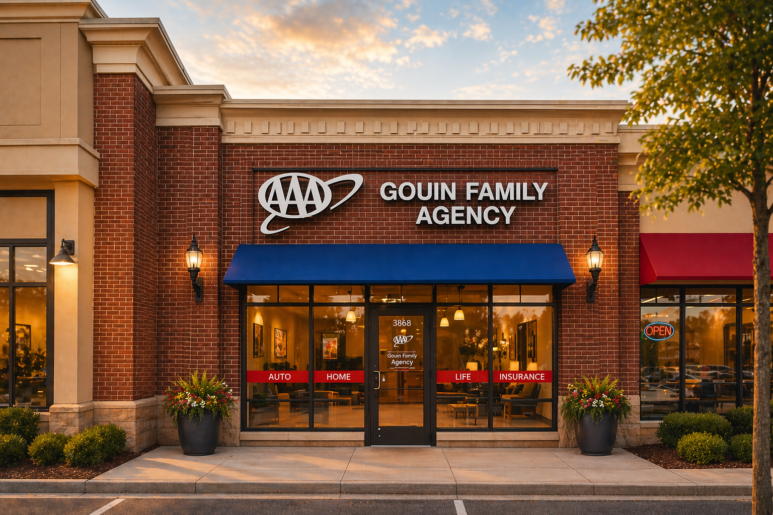 Brick storefront of AAA Gouin Family Agency with blue awning and red signage for auto, home, life, and insurance services.