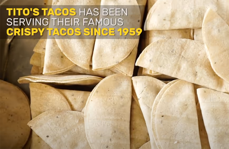 Close-up of uncooked tortillas folded in half with text stating Tito's Tacos has been serving their famous crispy tacos since 1959.