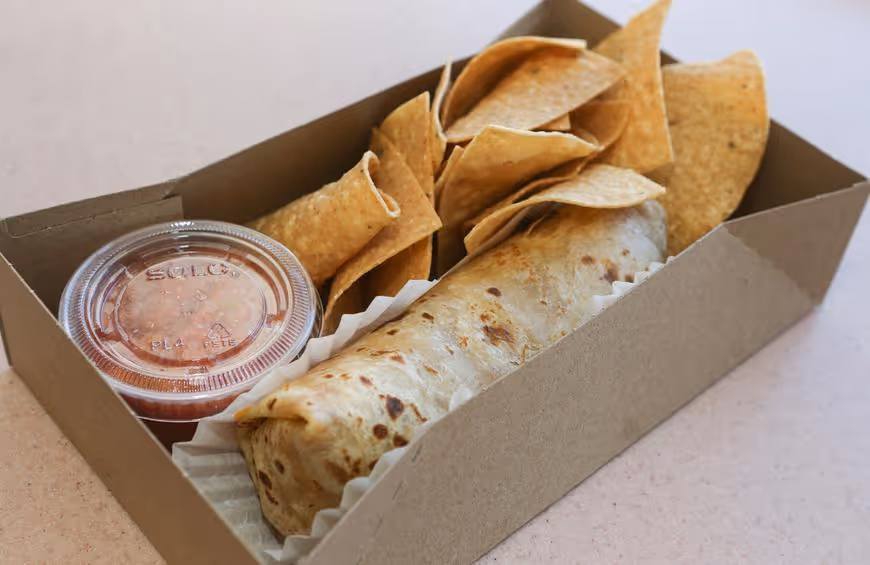 Box containing a burrito, tortilla chips, and a small container of salsa.