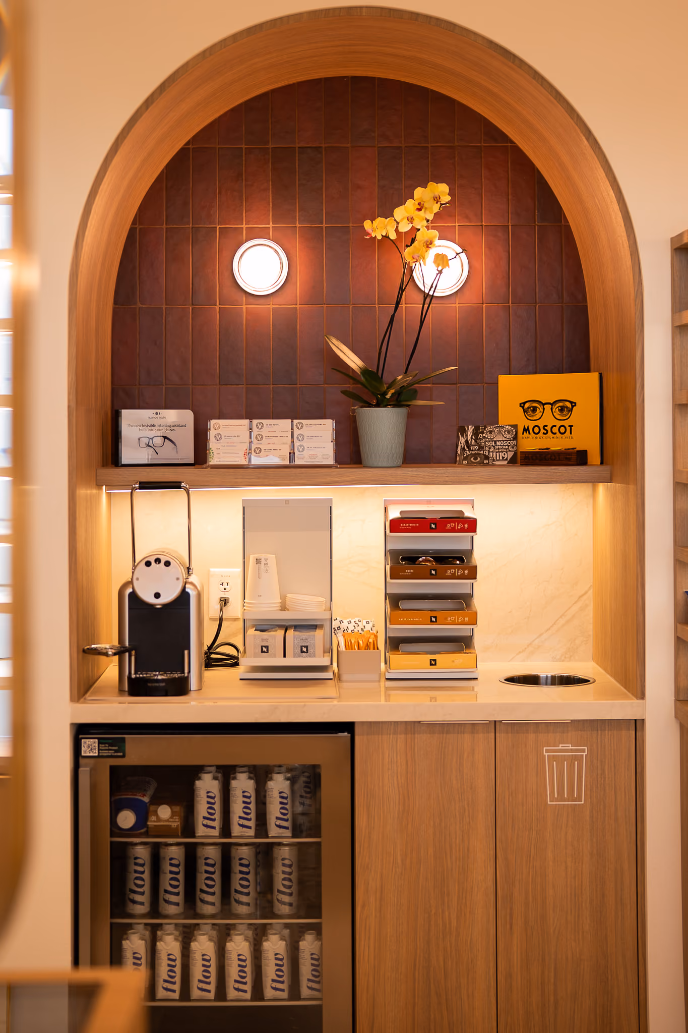 Reception area at Vision Care Woodward with an arched display alcove and dark wood cabinetry.