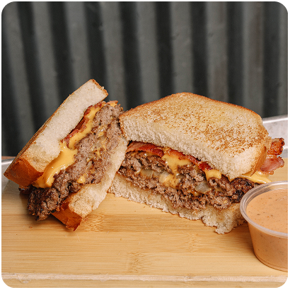 Buzz Bird smash burger on toasted bread with dipping sauce