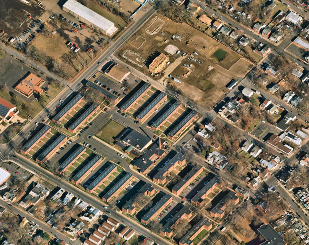 Aerial view of a residential area with rows of apartment buildings and surrounding streets.