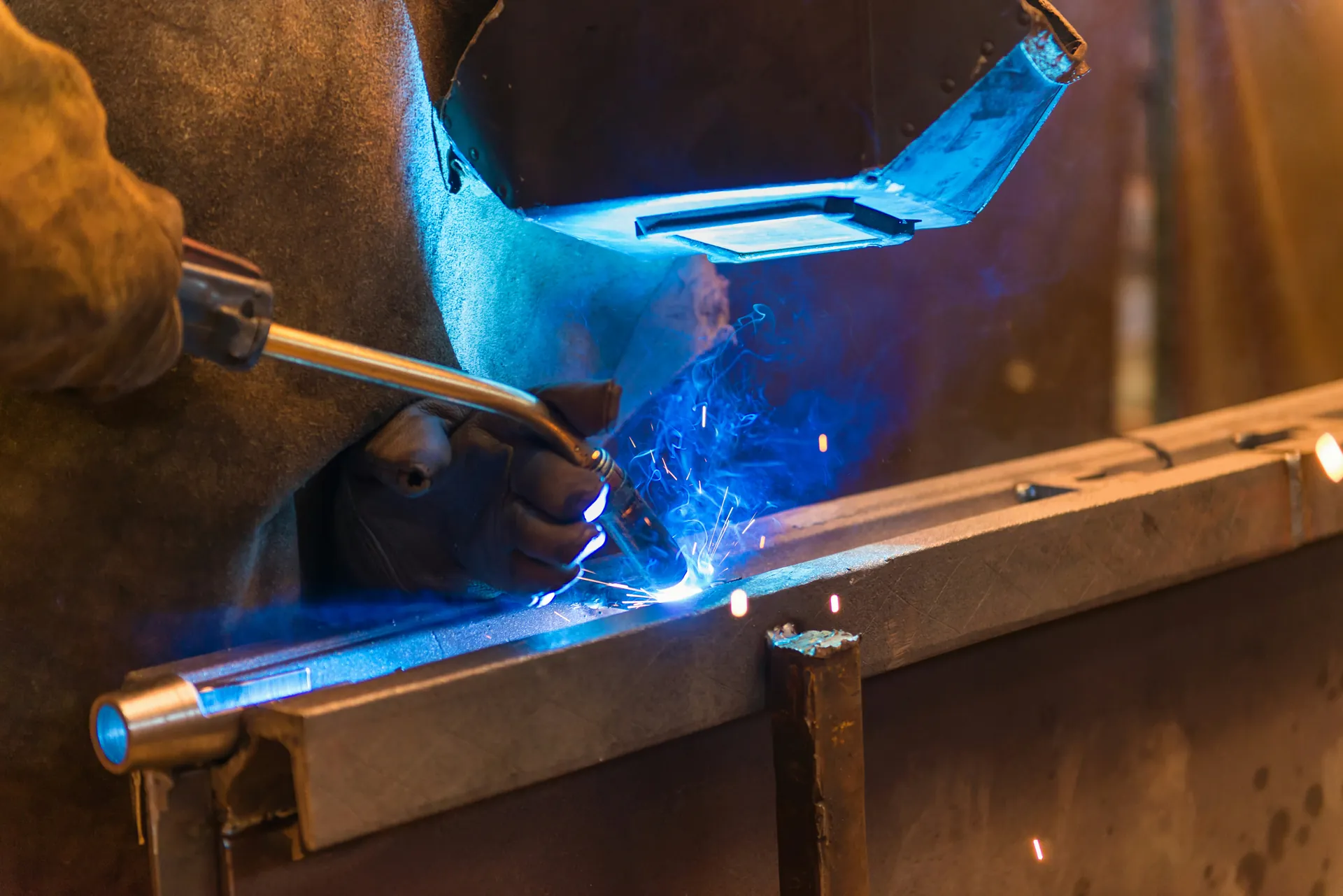 Welder fabricating an aerospace alloy forging with a blue flame torch
