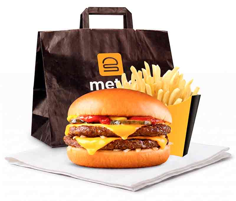Double cheeseburger with pickles, ketchup, onions, and two beef patties, served with French fries and a black Metro-branded takeout bag.