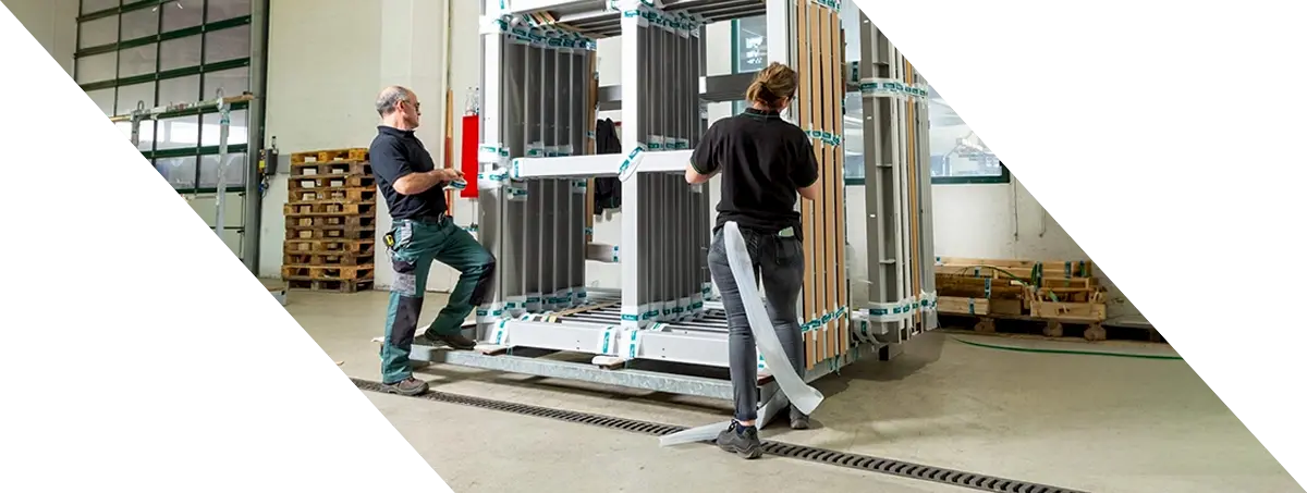 Mitarbeitende verpacken Aluminiumprofile fachgerecht für den sicheren Transport nach geprüften QUALICOAT Qualitätsstandards.