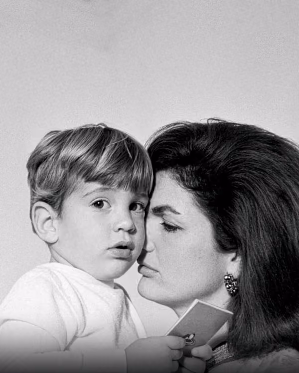 Black and white photo of a woman holding a child while looking at each other closely.