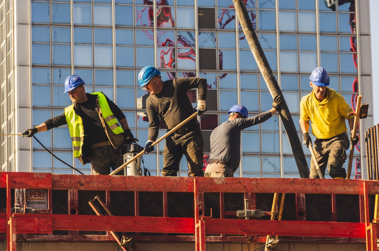 A crew of construction workers in hard hats on a high-rise job site