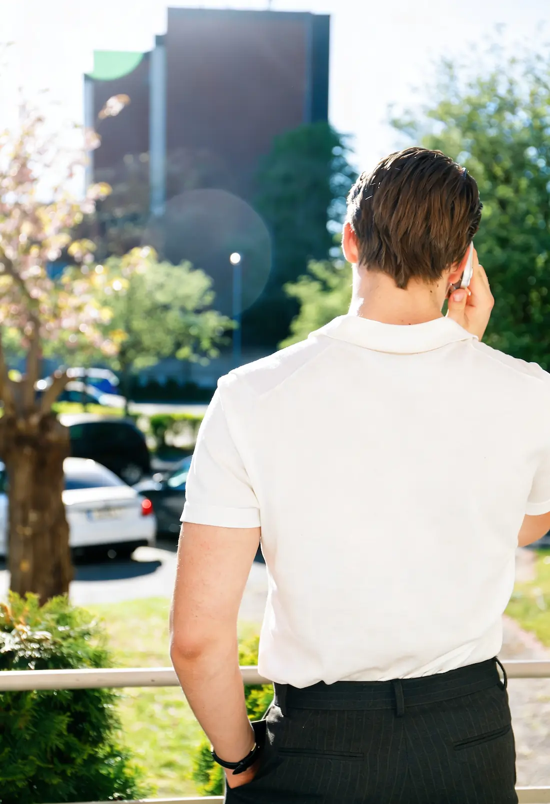 Gründer von Impression Marketing von hinten, der im Freien bei Tageslicht mit dem Handy telefoniert.