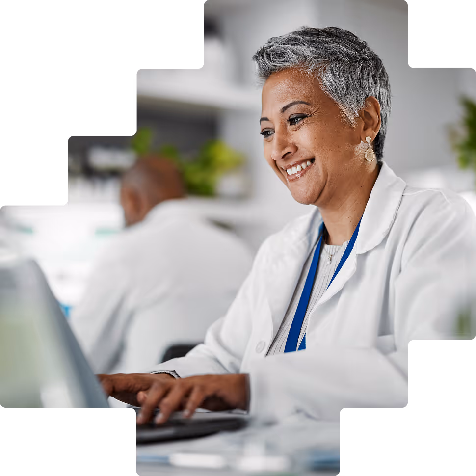Smiling pharmacist working at computer station