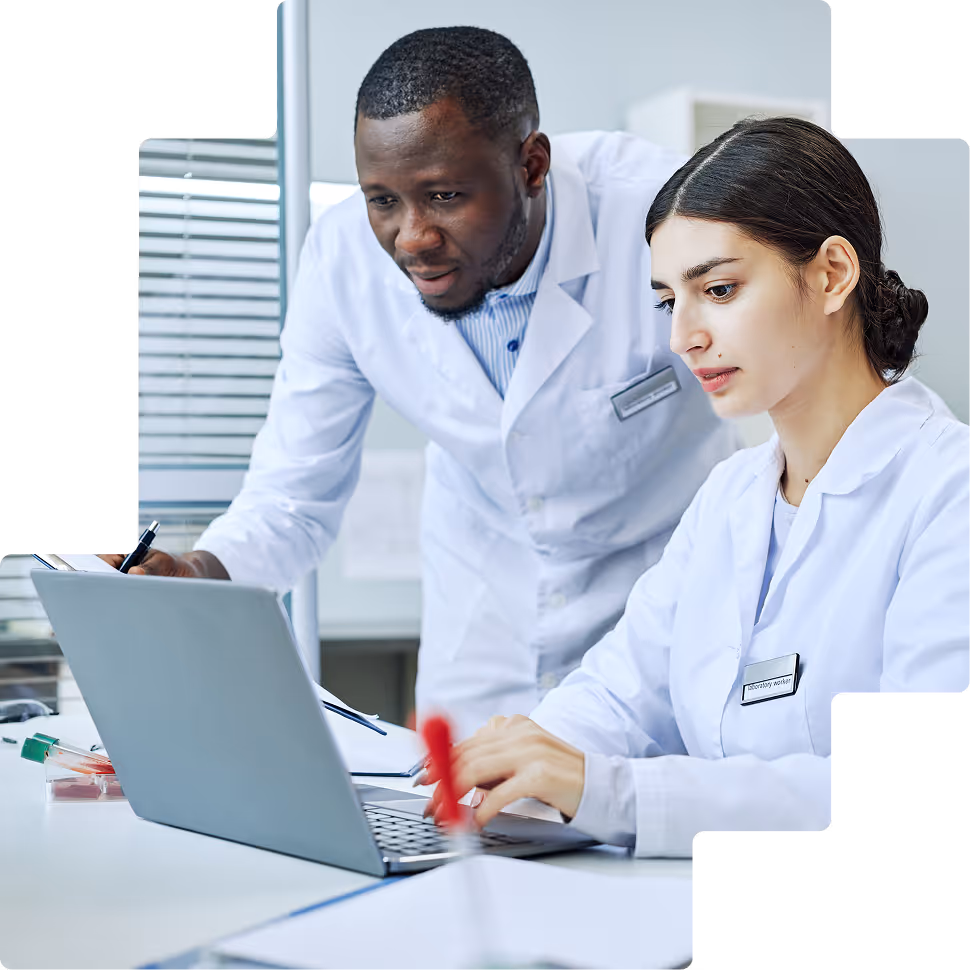 Two researchers reviewing data on laptop