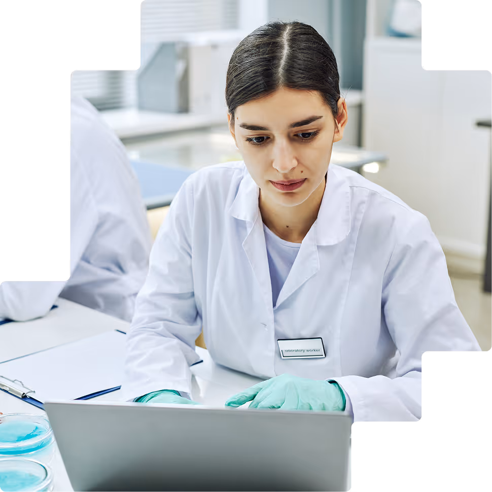 Female researcher with gloves typing on laptop