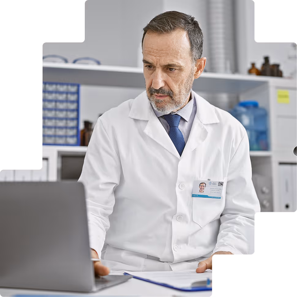 Doctor reviewing data on laptop in pharmacy