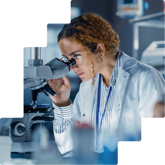 Medical researcher examining a specimen under a microscope in a clinical laboratory.