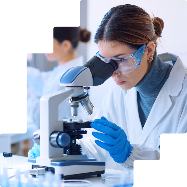 Woman at microscope: Female researcher analyzing samples through a microscope in a clinical laboratory