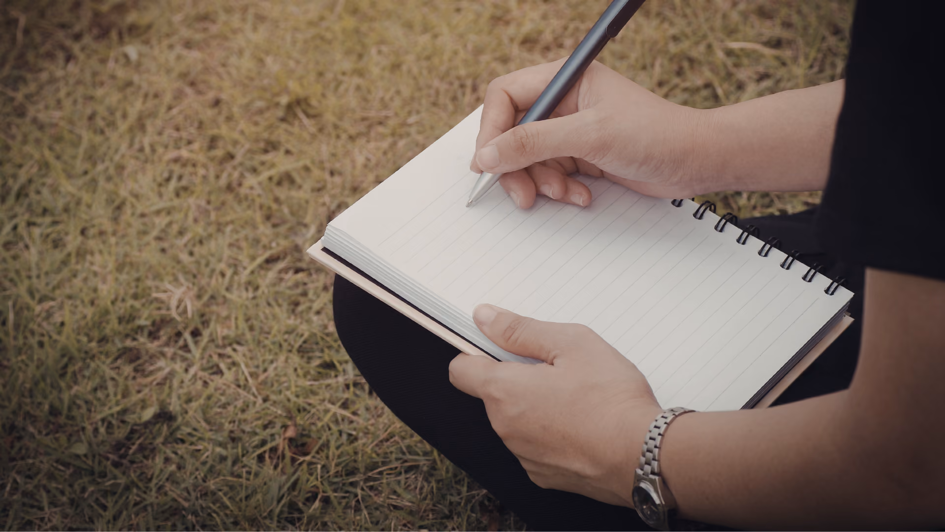 Open field notebook with bird sketches and notes next to binoculars in the field