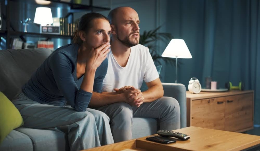 Pareja sentada en el sofá viendo una película | Mejores películas dramáticas para ver