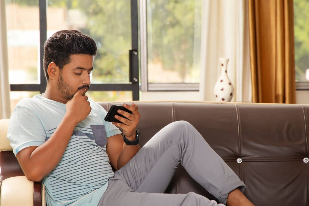 Hombre viendo una película en su teléfono | Películas para hacerte pensar