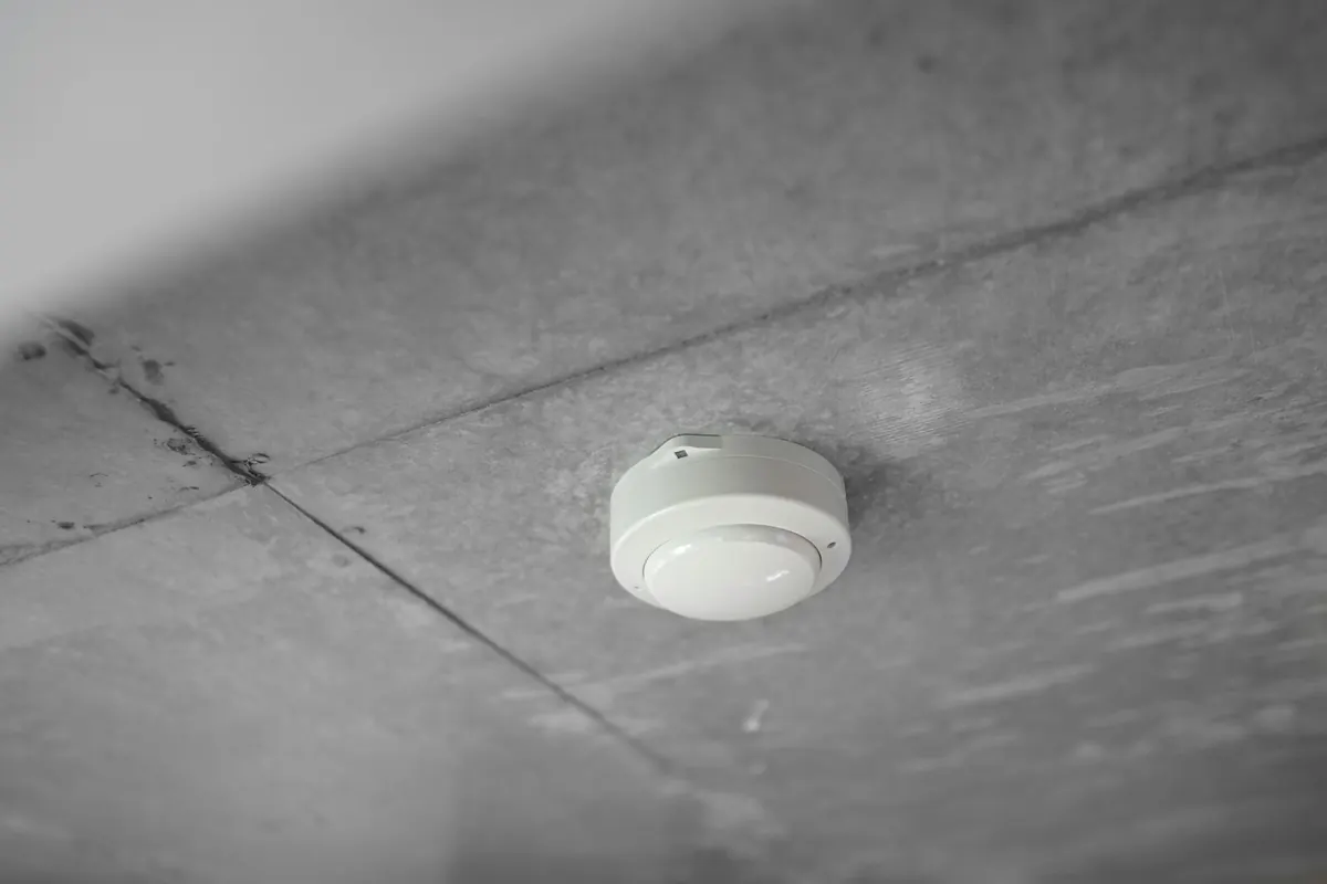 Licensed electrician installing interconnected smoke and CO detectors in a New Jersey home
