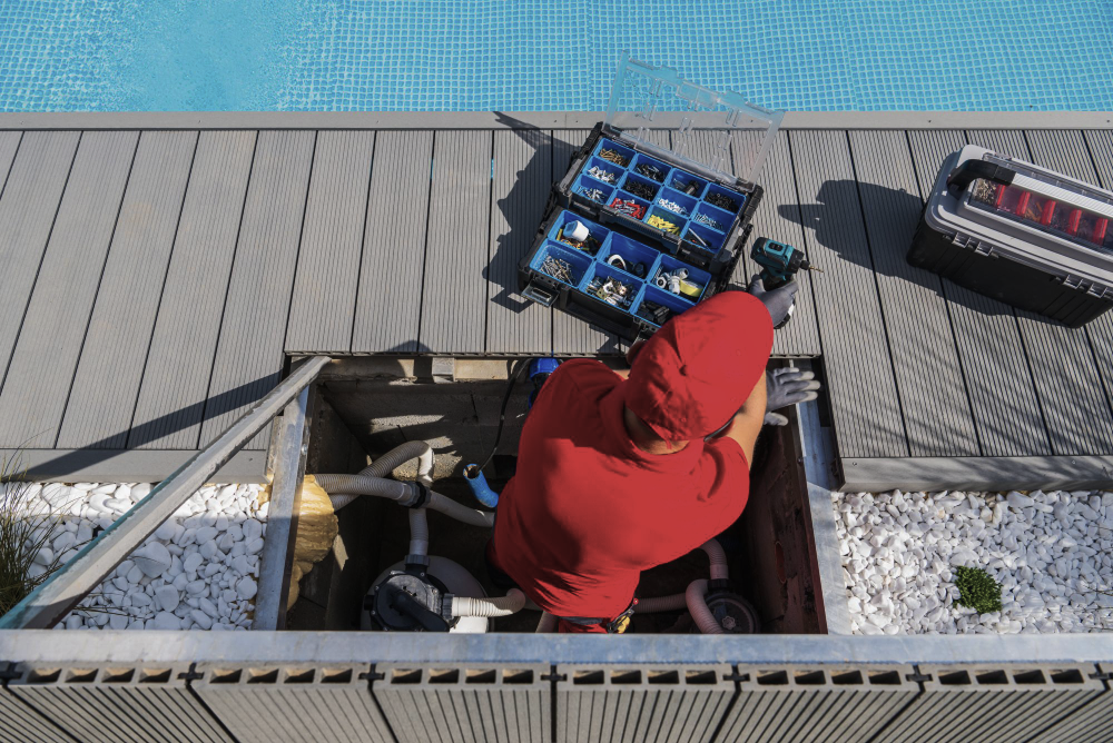 Outdoor air conditioning unit with exposed coil and electrical components, surrounded by snow and leaves.