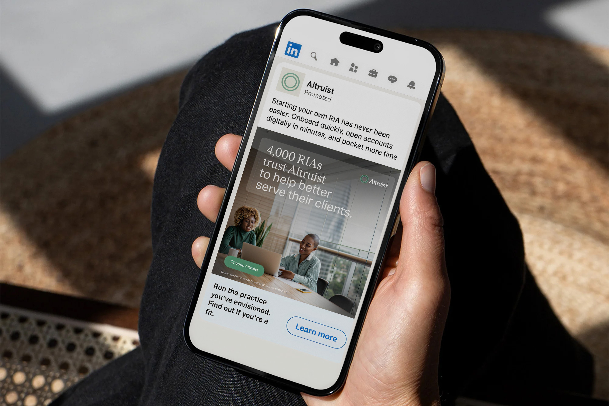 Hand holding phone showing LinkedIn ad for Altruist promoting easier digital onboarding for RIAs.