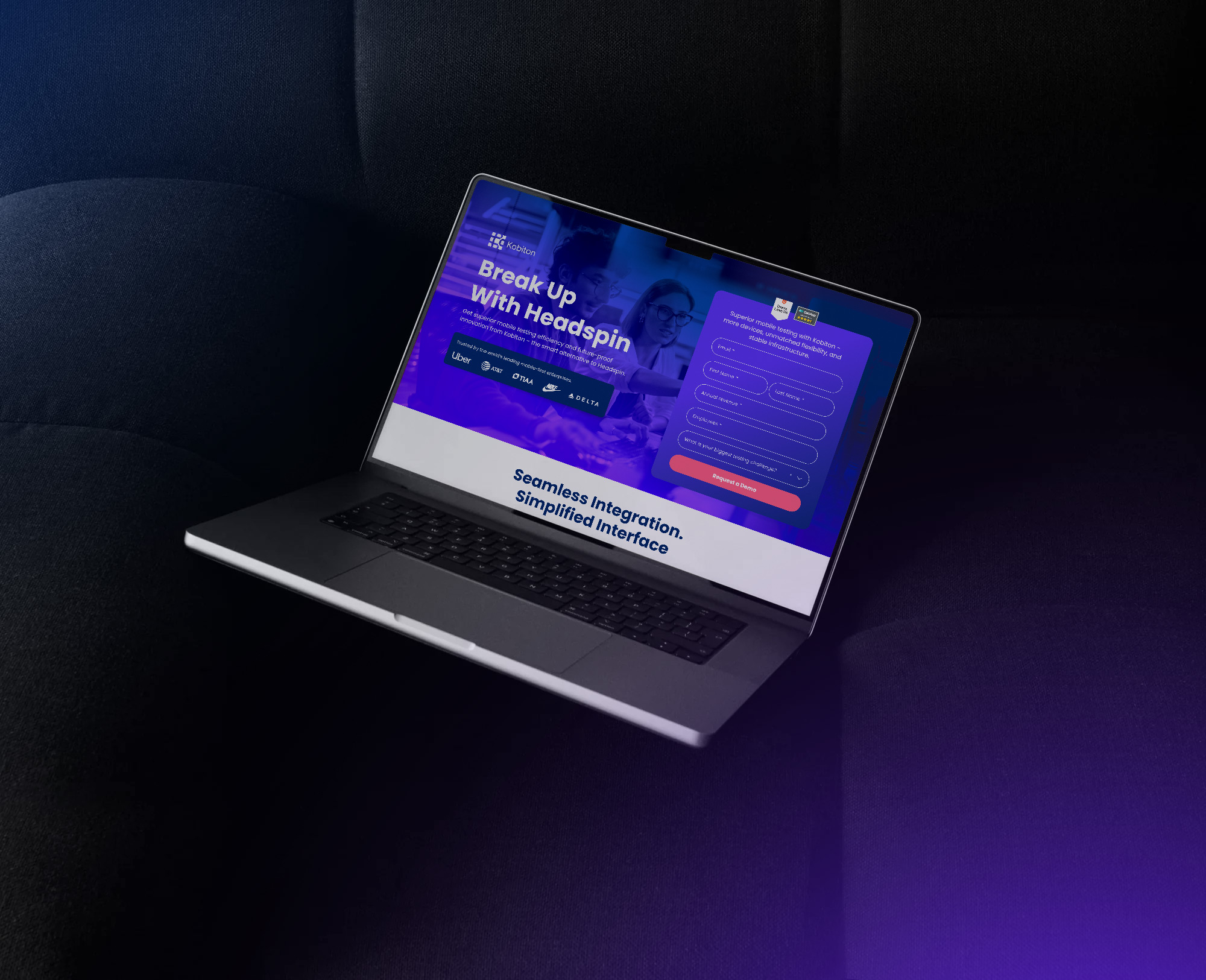 Laptop on dark sofa displaying a website about mobile testing with a demo request form on screen.
